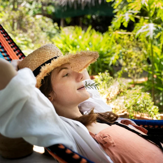 Jeune femme dans un hamac avec une brindille dans la bouche